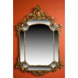 A PAIR OF HEAVY CAST BRASS PIER MIRRORS, early 20th century, each crested with a cherub within a