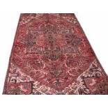 A RED GROUND PERSIAN RUG, 
with centre cruciform medallion,