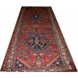 AN IRON RED GROUND HAMADAN RUNNER,