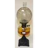 A LATE VICTORIAN CAST IRON OIL LAMP with moulded glass reservoir and frosted glass bulbous shade