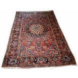 A BAKHTIARI RUG,
with iron red floral field and central star medallion, inside dark blue border,