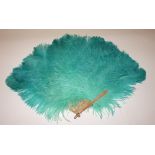 A VERY FINE GREEN OSTRICH FEATHER FAN, 
with mother o' pearl sticks and guards, 24in (61cm), boxed.