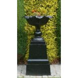A PAIR OF HEAVY LEAF CAST GARDEN URNS, 
each on a single gourd stem with square base,