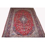 AN ATTRACTIVE PERSIAN KASHAN RUG, 
with navy and ivory floral medallion,