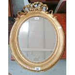 A 19TH CENTURY OVAL GILT WALL MIRROR, 
with ribbon bow crest on a moulded frame,