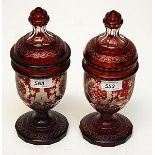 A PAIR OF BOHEMIAN RUBY GLASS URNS AND COVERS, 
each etched with cartouches,