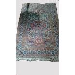 AN IVORY GROUND PERSIAN RUG,  
with all over floral field, inside a three band border,