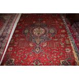 A BURGUNDY GROUND TABRIZ RUG, 
with centre navy and ivory medallion,