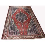 A PERSIAN MASLAGHAN RUG, 
with iron red field and central medallion with blue spandrelss,
