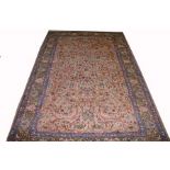 AN ATTRACTIVE KASHMIR RUG, 
the fawn field with an assortment of stylized flowers,