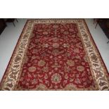 A HAND TUFTED INDIAN CARPET, 
the iron red field with an all over floral pattern,