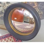 A CIRCULAR EBONISED AND PARCEL GILT WALL MIRROR, 
in the Regency style, 25in (64cm).