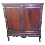 A CHIPPENDALE STYLE MAHOGANY TWO DOOR CUPBOARD OR COCKTAIL CABINET, 
the two cushion panel doors,