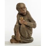 AN UNUSUAL LATE 19TH CENTURY TERRACOTTA FIGURE, 
modelled as a monkey holding an egg,