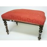 A RECTANGULAR VICTORIAN STOOL, 
with padded seat on turned legs, covered in peach fabric,