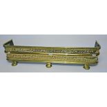 A 19TH CENTURY PIERCED BRASS FENDER,