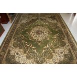 A LARGE ORIENTAL STYLE MACHINE MADE GREEN GROUND CARPET, 
with floral design and centre medallion,