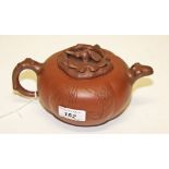 A TERRACOTTA COLOURED PUMPKIN SHAPED CHINESE TEA POT, 
with rustic handle and rustic cover,