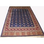 A KASHMIR BOKHARA DESIGN RUG, 
with six rows of oval medallions, within grided panels,