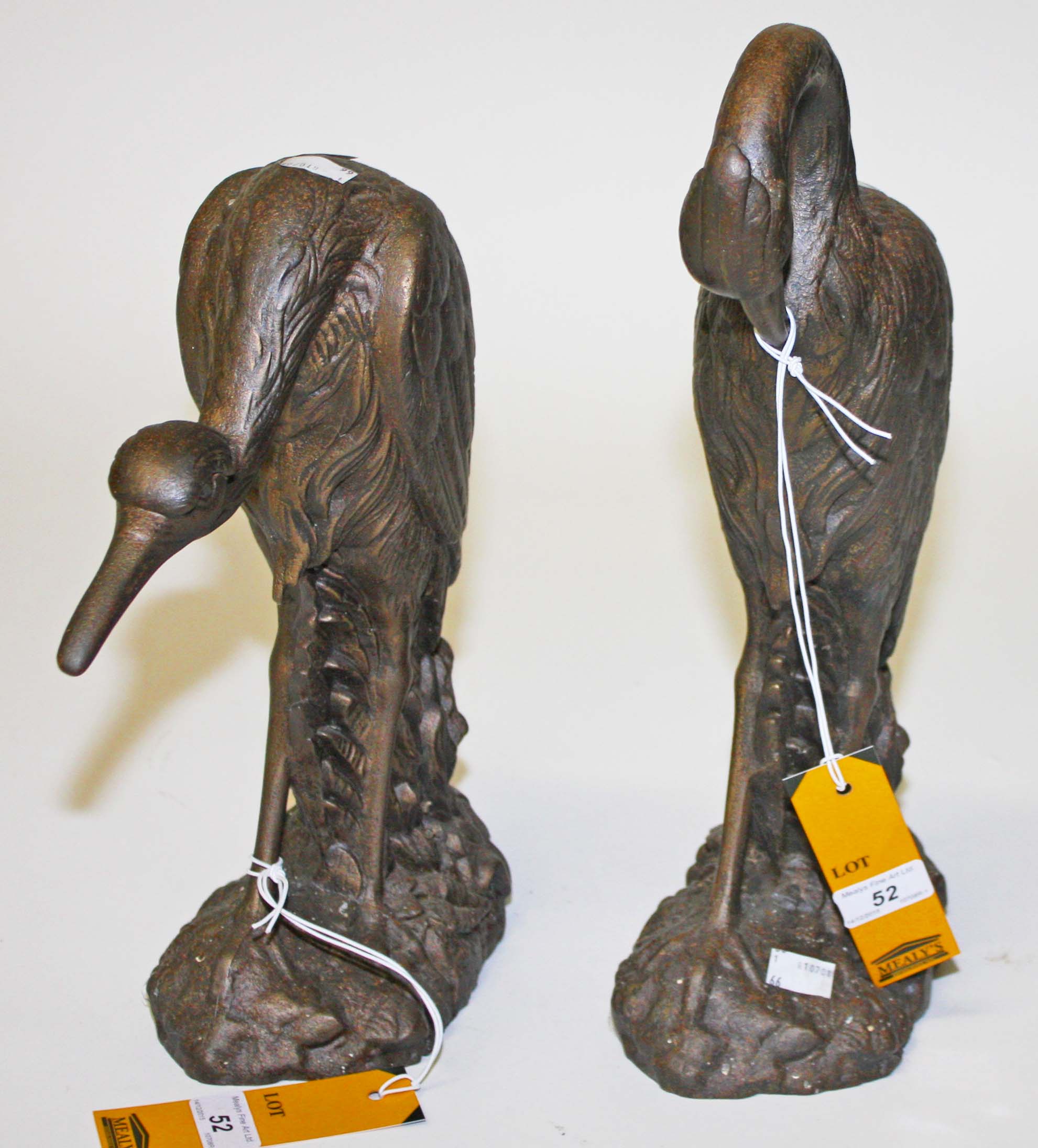 A PAIR OF HEAVY CAST IRON DOOR STOPS, 
each modelled as a crane standing amongst foliage,