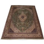 AN ATTRACTIVE ORIENTAL CARPET, 
with floral ivory central medallion, on a moss green floral field,