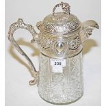 A CUT GLASS CLARET JUG, 
with silver plated mounts, rustic handle, and mask spout, 10.5in (27cm).