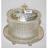 AN OVAL CUT GLASS BISCUIT JAR, 
with silver plated mounts, cover, and stand, 9in (23cm).