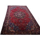 AN ATTRACTIVE MASHAD CARPET, 
with centre medallion on red floral field,