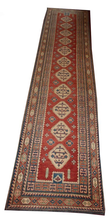 AN ATTRACTIVE ORIENTAL RUNNER, 
with a row of eleven octagons on iron red ground,
