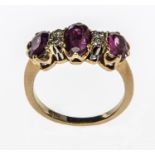 A FINE RUBY AND DIAMOND RING, 
with three various sized oval rubies,