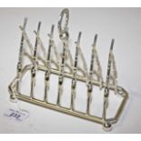 A SILVER PLATED TOAST RACK, 
with six divisions, each in the form of crossed rifles, 8in (20cm).