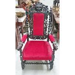 A CARVED OAK ARMCHAIR OR THRONE CHAIR, 
with grotesque mask crest, above a padded panel,