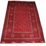 A BURGUNDY GROUND BOKHARA RUG, 
with three rows of hexagons inside a multi border,