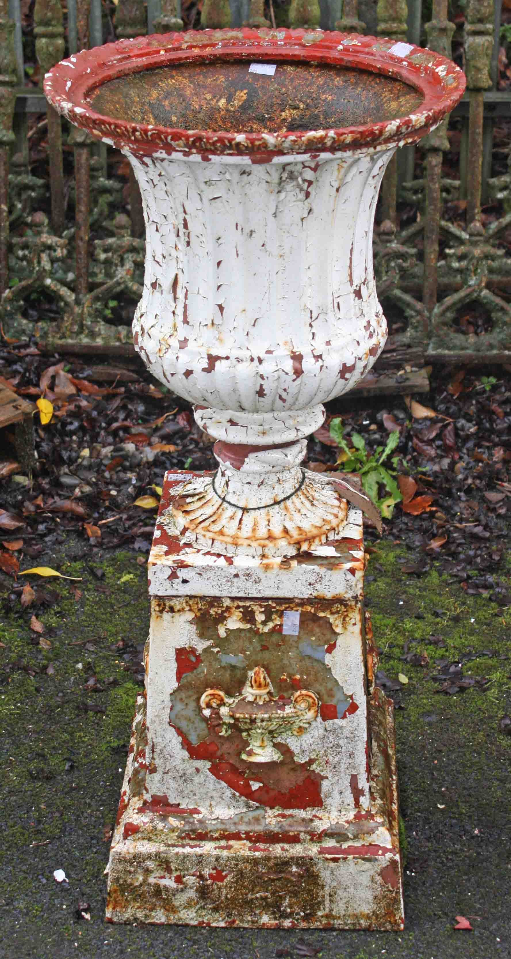 A PAIR OF ANTIQUE CAST IRON GARDEN URNS, 
each with a moulded edge,
