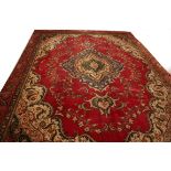A HERIZ CARPET, 
with centre floral medallion, on a burgundy floral ground within ivory,