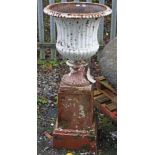 A HEAVY ANTIQUE CAST IRON GARDEN URN, 
the flared neck with a bead edge and half fluted reeded body,