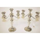 A PAIR OF TWO BRANCH THREE LIGHT SILVER PLATED CANDELABRA, 
each with two reeded scroll arms, 15.