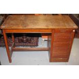 A SINGLE PEDESTAL OAK DESK, 
with rectangular top, above a tambour fronted pedestal, 45in (114cm)w.