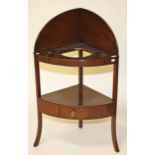 A BOW FRONTED MAHOGANY CORNER WASH STAND, 
in the Georgian style with arched gallery,