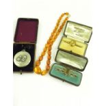 A NECKLACE OF FACETED AMBER BEADS, A CITRINE BAR BROOCH IN GOLD, CASED, ANOTHER IN SILVER AND AN