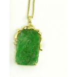 A CARVED AND PIERCED JADEITE PLAQUE, OF ARCHED FORM MOUNTED IN A DIAMOND SET GOLD PENDANT, ON GOLD