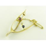 A DIAMOND, RUBY AND SAPPHIRE WISHBONE BROOCH IN GOLD, MARKED 15CT, C1910, 4.7G