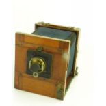 AN EARLY 20TH CENTURY MAHOGANY AND BRASS HALF PLATE CAMERA WITH LENS