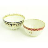 TWO CHELSEA DERBY TEA BOWLS, ONE BLUE AND GILT, THE OTHER ENAMELLED WITH FLOWERS BENEATH A CLARET