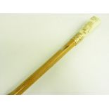 A BAMBOO WALKING CANE WITH CARVED IVORY HANDLE AND GILTMETAL FERRULE, C1900