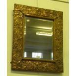 A RECTANGULAR MIRROR IN ARTS AND CRAFTS COPPER REPOUSSÉ FRAME