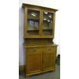 AN EDWARDIAN LIGHT OAK BOOKCASE, THE UPPER PART WITH GLAZED DOORS