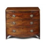 A REGENCY MAHOGANY BOW FRONTED CHEST OF DRAWERS, C1810   with brushing slide above three graduated