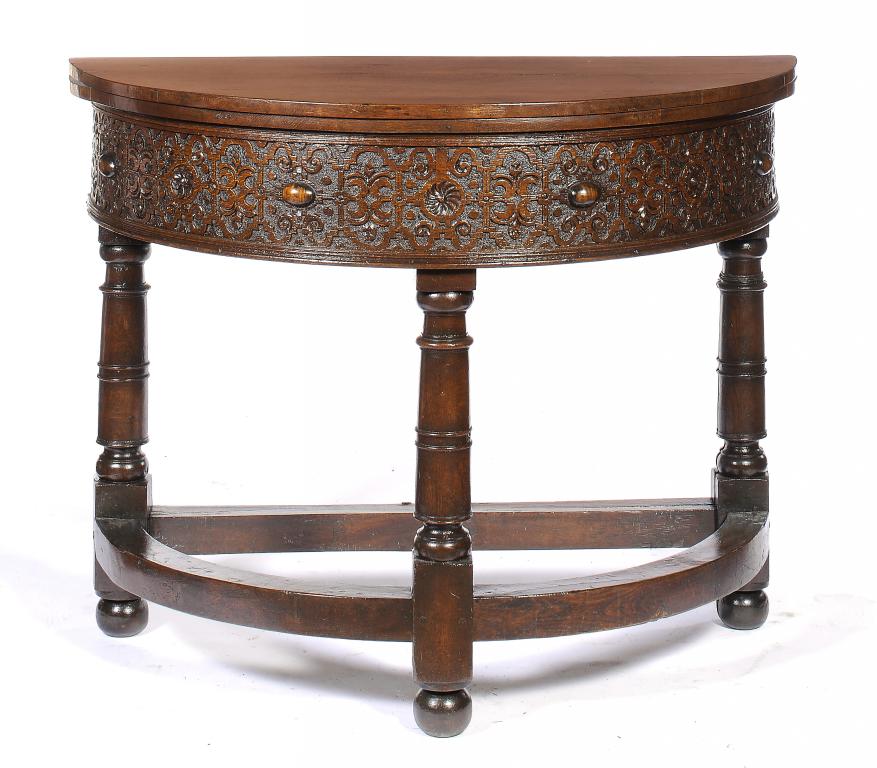 A JACOBEAN OAK FOLDING TABLE, EARLY 17TH C  the deep frieze carved with strapwork and applied