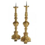 TWO MATCHING ITALIAN GILTWOOD ALTER CANDLESTICKS, 17TH C  the swollen centre knop carved with
